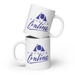 Pode incluir: Duas canecas de cerâmica branca empilhadas. Cada caneca apresenta o logotipo azul "America Online". O logotipo inclui um triângulo azul com um olho estilizado e as palavras "America Online" em itálico.