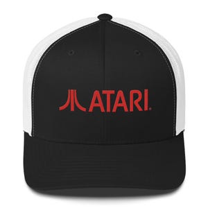 May include: A black and white trucker hat with a red embroidered Atari logo. The logo features the classic Atari game console graphic.