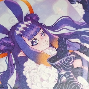 May include: A stack of art prints featuring a character with purple hair, bunny ears, and a black and white outfit. The character has a serene expression and is surrounded by a soft, ethereal background with a golden halo.