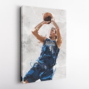 May include: A basketball player wearing a blue jersey with "Dallas 41" on the front, jumps to shoot a basketball against a white and gray background with blue paint splatters.