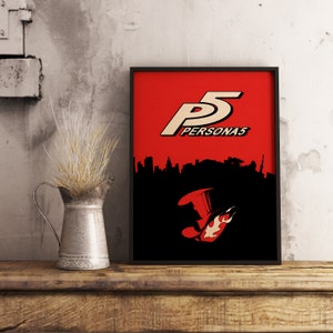 May include: A black framed poster with a red background featuring the Persona 5 logo and a silhouette of a city skyline. The logo is white with the text "PERSONA5" in white below it. The silhouette of a hat with a flame is in the bottom center of the poster.