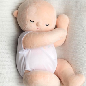 White toned realistically weighted baby doll with jointed limbs and a jointed head. The doll is 16" long, which is big enough to fit in preemie and some newborn clothing sizes, and weighs about 4 pounds. The doll has a soft filling similar to a stuffed animal and is weighted with quality glass beads. It is wearing a white onesie with the brand name, "Comfort Cuties."