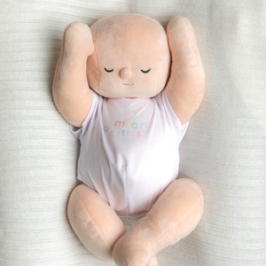 White toned realistically weighted baby doll with jointed limbs and a jointed head. The doll is 16" long, which is big enough to fit in preemie and some newborn clothing sizes, and weighs about 4 pounds. The doll has a soft filling similar to a stuffed animal and is weighted with quality glass beads. It is wearing a white onesie with the brand name, "Comfort Cuties."