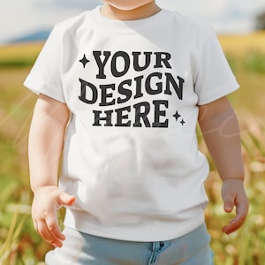Puede incluir: Camiseta blanca para ni&ntilde;os peque&ntilde;os con mangas cortas y el texto "YOUR DESIGN HERE" impreso en negro.