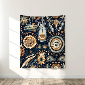 Puede incluir: Un tapiz rectangular con un patr&oacute;n repetido de dise&ntilde;os florales y celestiales estilizados en azul marino, naranja y crema. La obra de arte presenta soles, ojos y otras formas org&aacute;nicas, creando un vibrante tapiz decorativo para la pared.