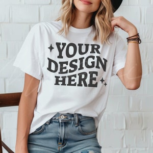 Può includere: Maglietta bianca con il testo "YOUR DESIGN HERE" in lettere nere con una stella su entrambi i lati del testo.