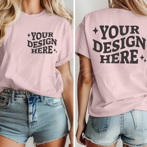 以下が含まれることがあります： 短い袖とクルーネックのピンクのTシャツ。シャツの前には「YOUR DESIGN HERE」というテキストが黒で印刷されています。シャツの後ろには同じテキストが黒で印刷されています。