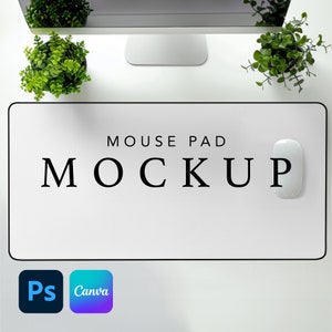 Op de afbeelding: Een wit muismatje met zwarte tekst die "MOUSE PAD MOCKUP" luidt. Een witte computermuis ligt op het matje. Het matje ligt op een wit oppervlak met twee kleine groene planten in potten.