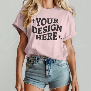 May include: A pink t-shirt with the text "YOUR DESIGN HERE" in black lettering with small stars on either side of the text.