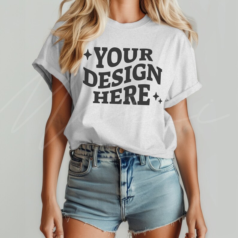 K&ouml;nnte beinhalten: Ein wei&szlig;es T-Shirt mit dem Text "YOUR DESIGN HERE" in schwarzer Schrift mit kleinen Sternen auf beiden Seiten des Textes.