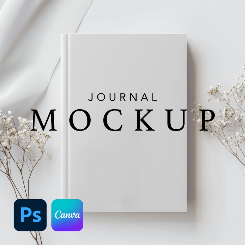 May include: White journal mockup with the text "JOURNAL MOCKUP" on the cover. The journal is on a white surface with white flowers on either side.