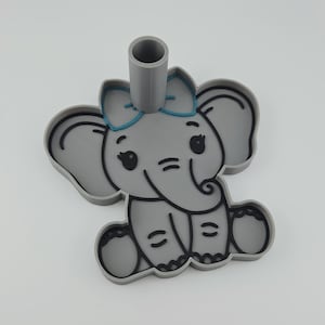 Op de afbeelding: Een grijze koekjesvorm in de vorm van een olifant met een blauwe strik op het hoofd. Het ontwerp bevat zwarte omlijningen voor de ogen, oren, slurf en voeten, met een cilindrisch handvat dat verticaal vanaf de bovenkant omhoog steekt.