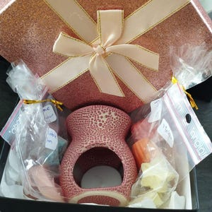 box filled with burner, scented melts, and candles