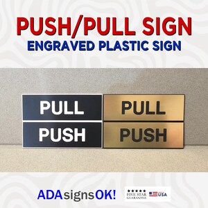 Puede incluir: Dos letreros de plástico grabados con letras negras y doradas. El letrero superior dice "PULL" en negro sobre fondo dorado y el letrero inferior dice "PUSH" en negro sobre fondo dorado. El segundo letrero es el mismo pero con los colores invertidos. Los letreros están etiquetados como "PUSH/PULL SIGN" y "ENGRAVED PLASTIC SIGN".