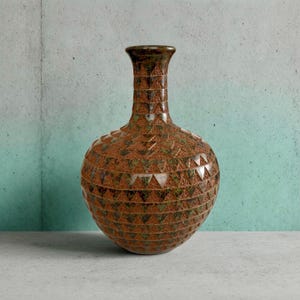 May include: A decorative brown vase with a textured surface and a geometric triangle pattern. The vase has a rounded body and a narrow neck. The color palette includes shades of brown and green.