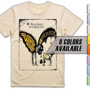 May include: A cream-coloured t-shirt with a retro graphic from "The Fearless Vampire Killers." The design features a bat-like figure with dripping blood and the phrases "Who says Vampires are no laughing matter?" and "Pardon me. But Your Teeth are in My NECK."
