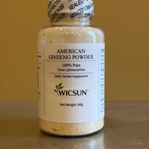 May include: A clear glass jar filled with light beige American Ginseng Powder. The label reads "American Ginseng Powder 100% Pure Panax Quinquefolius Daily Herbal Supplement" with the brand name "WICSUN". The jar is sealed with a tamper-evident seal.
