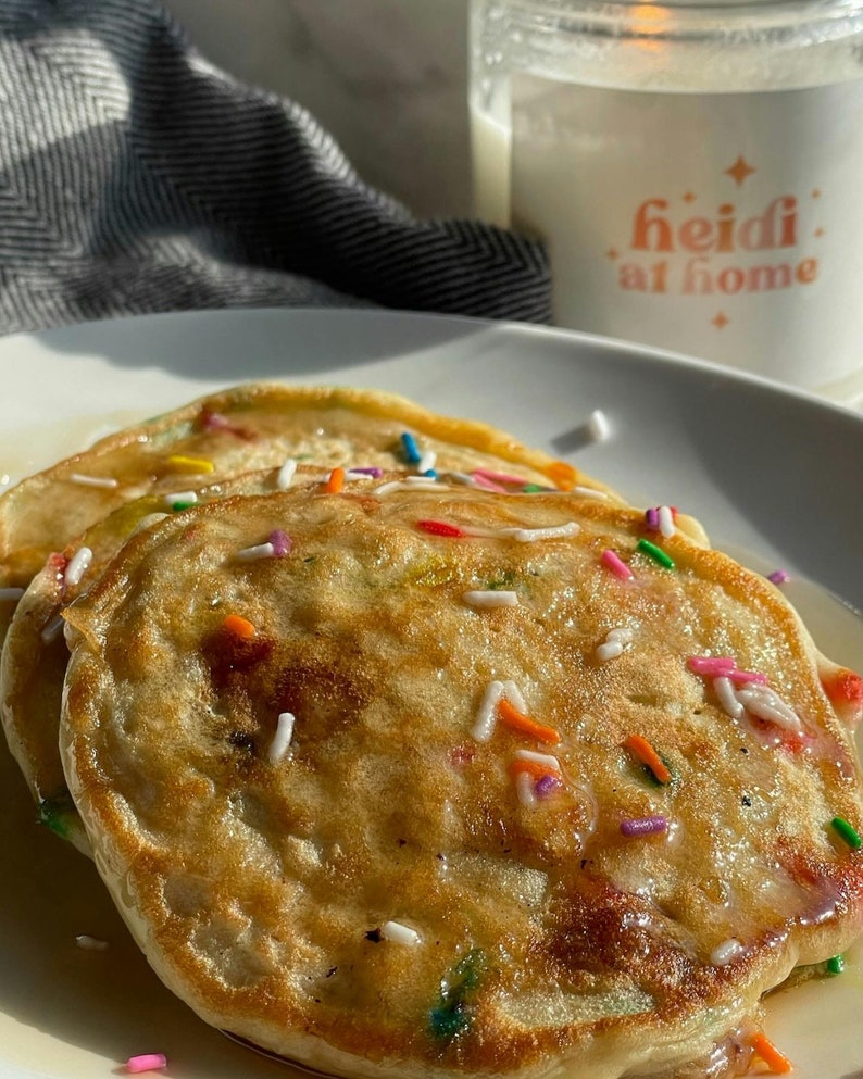 Pu&ograve; includere: Due pancake dorati ricoperti di codette bianche e colorate e un filo di sciroppo.