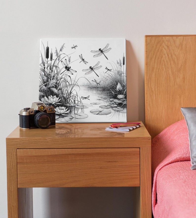Canvas art on a bedside tabel. The canvas wall art features an elegant black and white line art scene of dragonflies gracefully hovering over a tranquil pond.