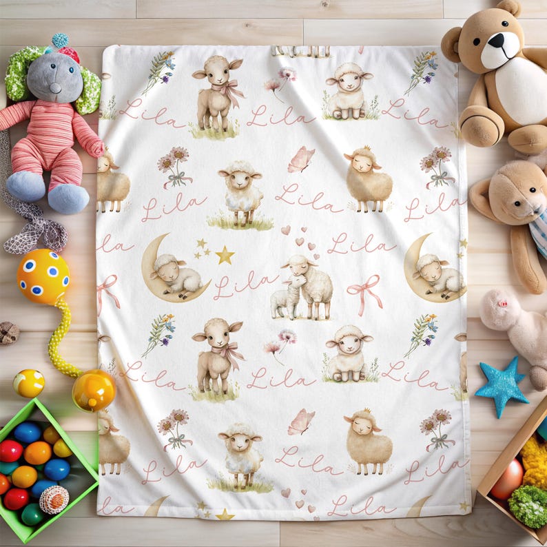 A personalized custom name white velveteen blanket with whimsical lambs, pink bows, stars, flowers, hearts and butterflies laying on the floor surrounded by toys.