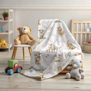 A personalized custom name white velveteen blanket with whimsical lambs, pink bows, stars, flowers, hearts and butterflies draped over a chair in a playroom