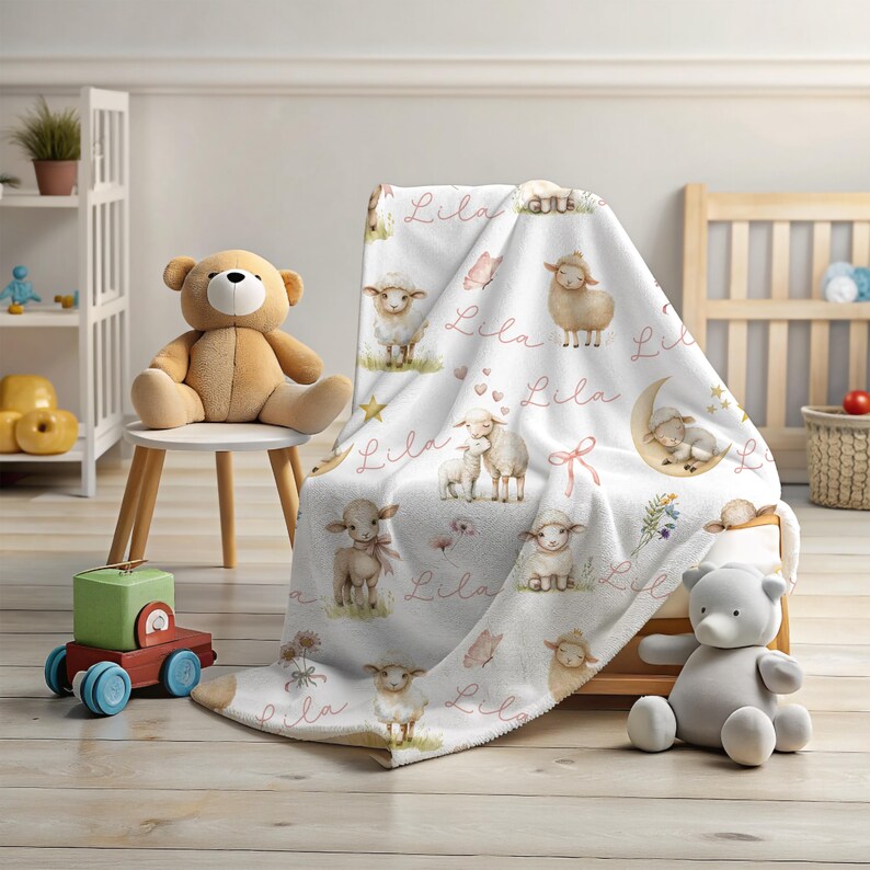 A personalized custom name white velveteen blanket with whimsical lambs, pink bows, stars, flowers, hearts and butterflies draped over a chair in a playroom