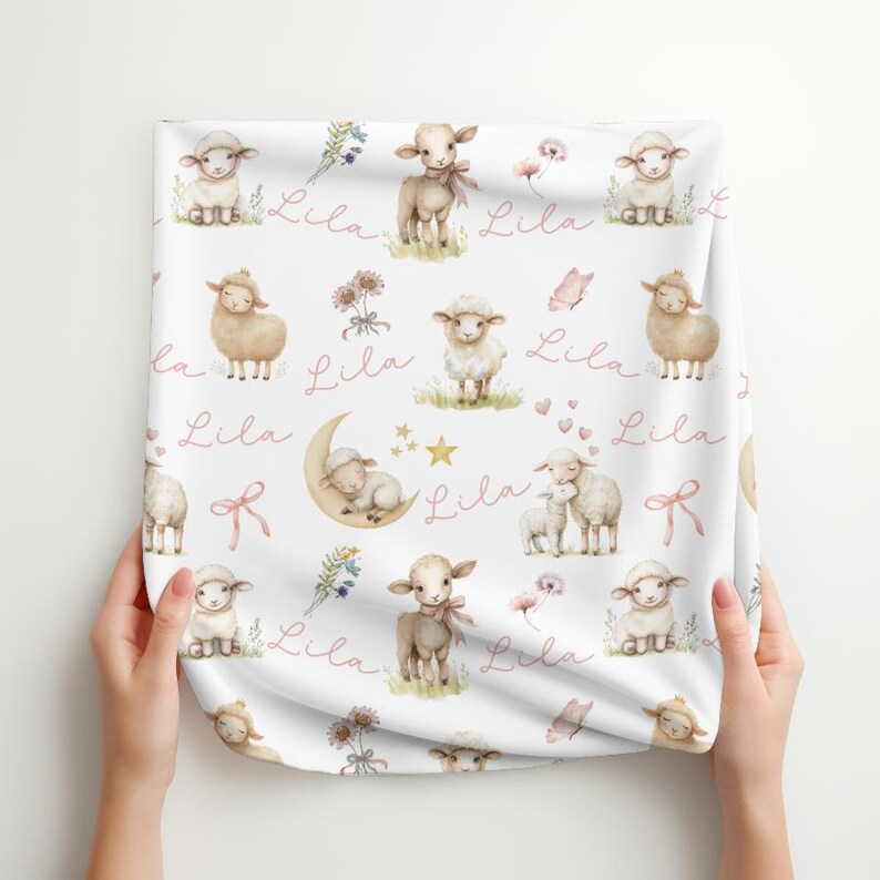A folded personalized custom name white velveteen blanket with whimsical lambs, pink bows, stars, flowers, hearts and butterflies.