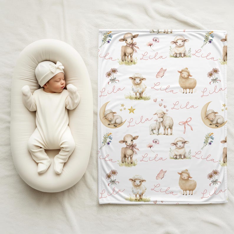 A baby laying beside a personalized custom name white velveteen blanket with whimsical lambs, pink bows, stars, flowers, hearts and butterflies draped over a crib.