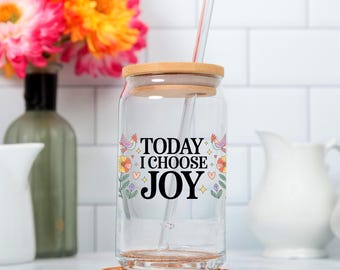 May include: A clear glass tumbler with a bamboo lid and a glass straw. The glass features the black text "TODAY I CHOOSE JOY" surrounded by colorful illustrations of small birds, flowers, hearts, and stars printed on the front surface.