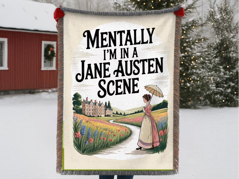 May include: A beige throw blanket with a decorative fringe and the text "Mentally I'm in a Jane Austen Scene." The blanket features a colourful illustration of a woman with an umbrella walking on a path near a mansion.