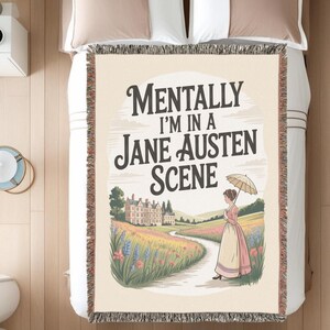 May include: Woven throw blanket with the text "Mentally I'm in a Jane Austen Scene." The design features a woman in a period dress holding an umbrella, walking on a path towards a manor house. The blanket has a cream background.