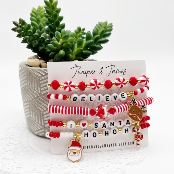 Pulseras navideñas apiladas: pulseras navideñas con cuentas y dijes de Papá Noel