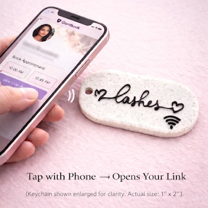May include: A white, rectangular keychain with the word "lashes" in black script, two heart symbols, and a Wi-Fi symbol. The keychain is being tapped by a smartphone displaying a booking app. The text reads "Tap with Phone → Opens Your Link."