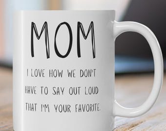 May include: White ceramic coffee mug with black text that reads "MOM I LOVE HOW WE DON'T HAVE TO SAY OUT LOUD THAT I'M YOUR FAVORITE."