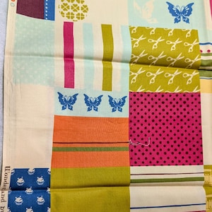 Może przedstawiać: Tkanina patchworkowa z różnymi wzorami i kolorami. Projekt zawiera niebieskie motyle, różowe kropki, zielone nożyczki oraz niebieskie i białe kwadraty. Tkanina zawiera tekst "Wonderland by MoMo for moda fabrics".