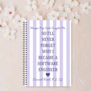 Op de afbeelding: Een spiraalgebonden notitieboek met een paars en wit gestreepte kaft. De kaft bevat de tekst "Things My Code Taught Me" en "SO I'LL NEVER FORGET WHY I BECAME A SOFTWARE ENGINEER." De naam en graad van de auteur zijn ook opgenomen.