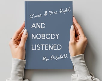 Könnte beinhalten: Ein blaues Buch mit dem Titel "Times I Was Right And Nobody Listened" von Elizabeth. Der Titel des Buches ist in weißer, stilisierter Schrift gehalten. Das Buch wird von zwei Händen mit manikürten Nägeln gehalten.