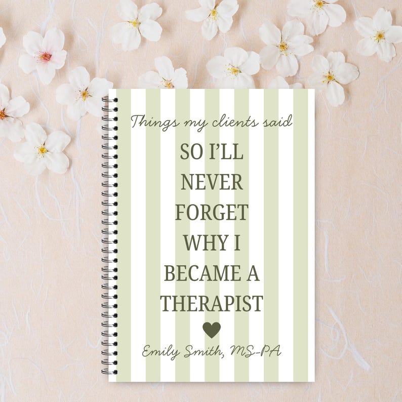 May include: A notebook with a spiral binding, featuring a cover with green and white vertical stripes. The cover displays the text: "Things my clients said, so I'll never forget why I became a therapist." The author's name is also included.