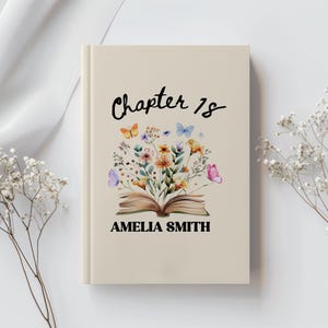 Pode incluir: Uma capa de livro bege com as palavras "Chapter 18" em escrita preta. A capa apresenta uma ilustração em aquarela de um livro aberto com flores e borboletas. O nome "AMELIA SMITH" é impresso abaixo da ilustração.
