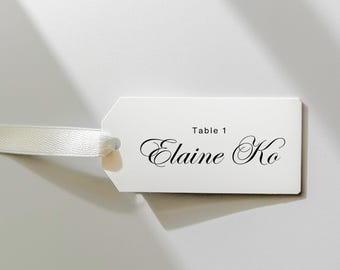 Könnte beinhalten: Weiße Tischkarte mit schwarzem Text. Der Text lautet "Tisch 1 Elaine Ko".