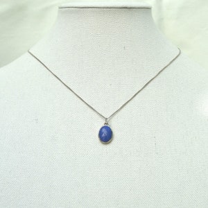 May include: A silver chain necklace with a blue oval pendant.