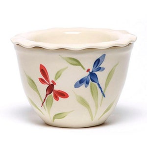 May include: A white ceramic bowl with a scalloped rim features a hand-painted design of two dragonflies. One dragonfly is blue and the other is red.