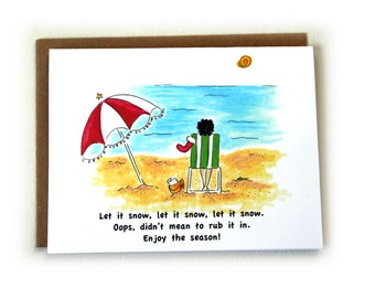 May include: A Christmas card with a cartoon illustration of a person sitting on a beach chair under a red and white beach umbrella with Christmas lights. The text on the card reads: "Let it snow, let it snow, let it snow. Oops, didn't mean to rub it in. Enjoy the season!"
