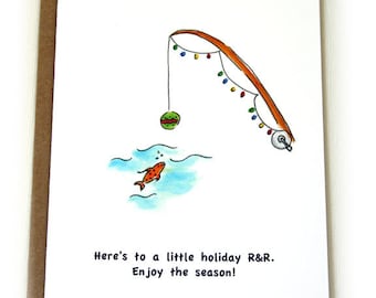 May include: A greeting card with a hand-drawn illustration of a fishing rod with Christmas lights, a red and green ornament, and a gold fish swimming in blue water. The text reads "Here's to a little holiday R&R. Enjoy the season!"