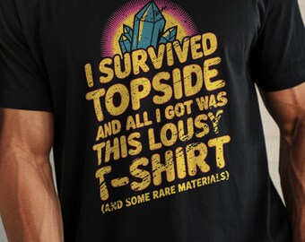 May include: Black t-shirt with the text "I SURVIVED TOPSIDE AND ALL I GOT WAS THIS LOUSY T-SHIRT (AND SOME RARE MATERIALS)". The graphic includes a crystal design with yellow and blue accents. The word "BLACK" is at the bottom.