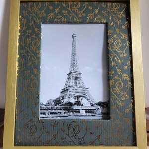 Könnte beinhalten: Ein goldfarbener Bilderrahmen mit einer grünen Passepartout und einem Schwarzweißfoto des Eiffelturms. Die Passepartout hat ein goldenes Blumenmuster.
