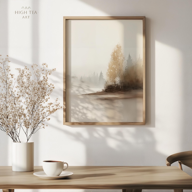 Op de afbeelding: Een ingelijste kunstafdruk met een serene bossc&egrave;ne in gedempte tinten. Het kunstwerk toont bomen en een mistig meer, met een warm, gouden licht. De tekst "HIGH TEA ART" staat in de linkerbovenhoek.