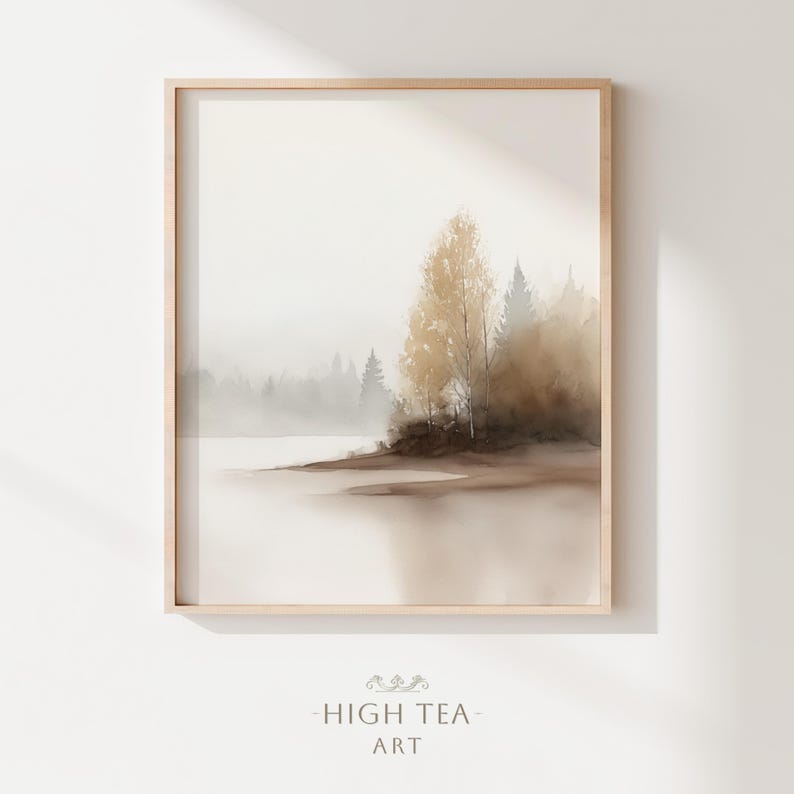 Op de afbeelding: Een ingelijste aquarelprint van een serene landschap. Het kunstwerk toont een mistige meer sc&egrave;ne met bomen in bruin- en goudtinten. De print zit in een licht houten frame en heeft de tekst "HIGH TEA - ART" onderaan.