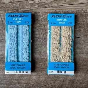 May include: Two packages of 2 yards of stretchable, ruffled trim made of 100% nylon. The trim is available in light blue and beige. The packages are labeled "Flexi-Lace Ruffled Trim 70c".