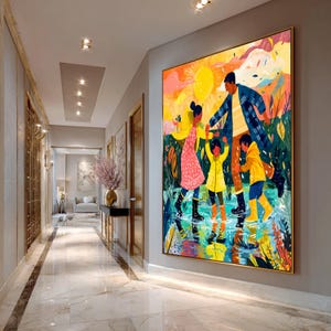 Op de afbeelding: Een groot ingelijst schilderij toont een gezin dat door water waadt onder een heldere zon. Het kunstwerk toont een vaderfiguur, twee kinderen in gele regenjassen en een meisje in een roze jurk. De stijl is kleurrijk en illustratief, met een focus op de natuur.